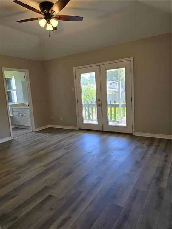 spare room featuring dark hardwood / wood-style flooring, lofted ceiling, french doors, and ceiling fan