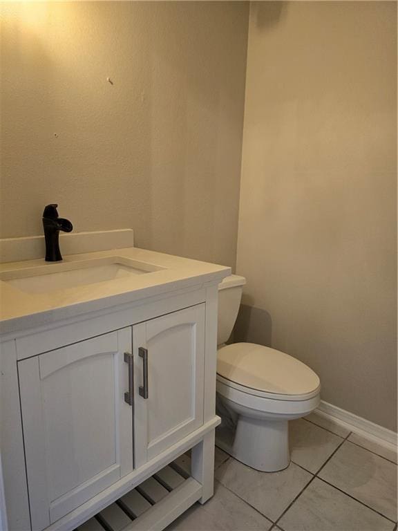 bathroom with vanity, tile patterned flooring, and toilet