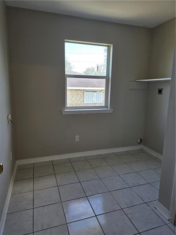 laundry room featuring electric dryer hookup and light tile patterned flooring