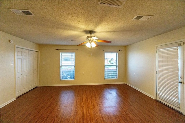 empty room featuring hardwood / wood-style flooring, ceiling fan, and a textured ceiling