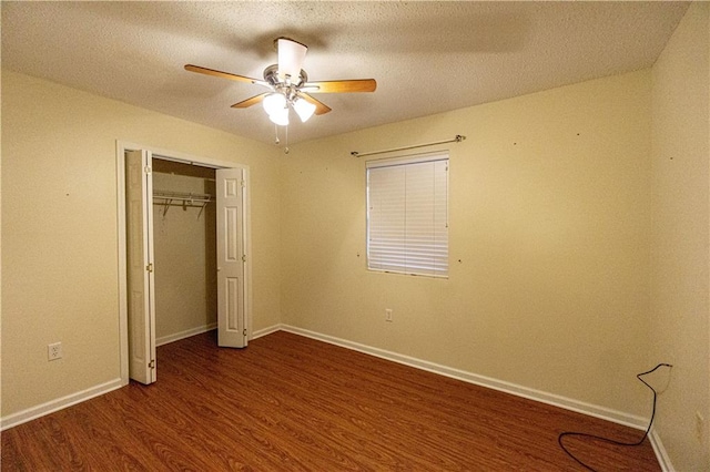 unfurnished bedroom with a textured ceiling, a closet, ceiling fan, and dark wood-type flooring