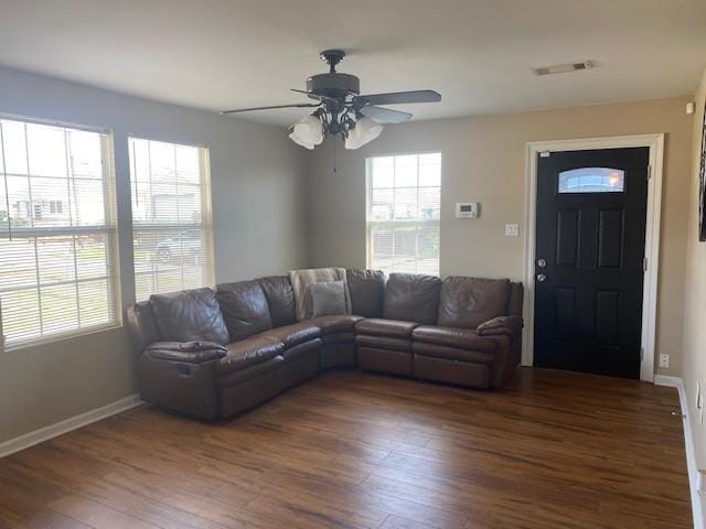 living room featuring ceiling fan and dark hardwood / wood-style floors