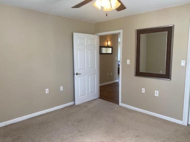 carpeted empty room featuring ceiling fan