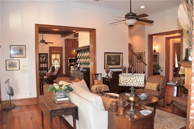 living room with dark hardwood / wood-style floors, ornamental molding, and ceiling fan