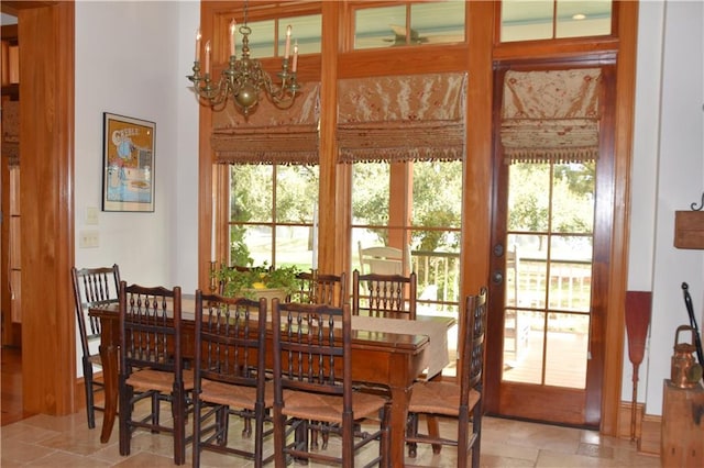 dining area featuring a notable chandelier, a healthy amount of sunlight, light tile floors, and french doors