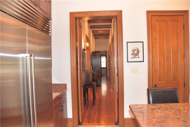 hallway with dark hardwood / wood-style flooring and beam ceiling