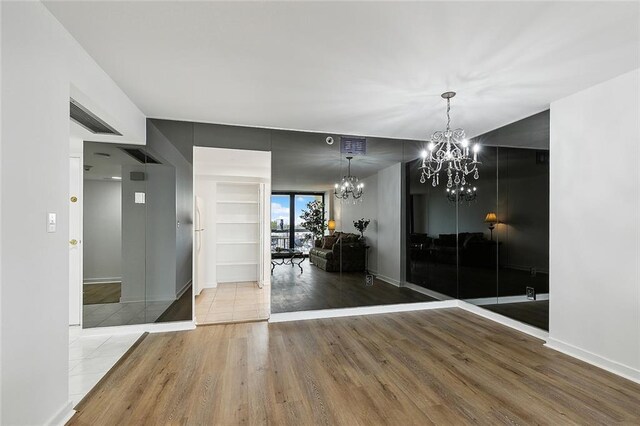 unfurnished dining area featuring hardwood / wood-style flooring and a notable chandelier