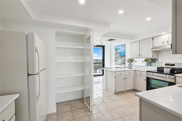 kitchen with white cabinets, light tile patterned floors, white refrigerator, and stainless steel range