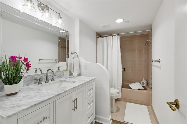 full bathroom featuring toilet, tile patterned flooring, shower / bath combo with shower curtain, and vanity