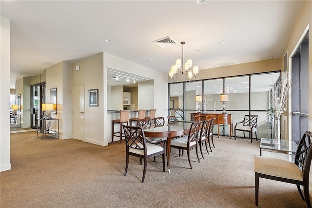 dining area featuring carpet, visible vents, a chandelier, and baseboards