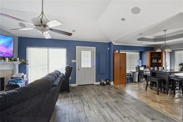 living room with crown molding, ceiling fan, hardwood / wood-style floors, and a tray ceiling