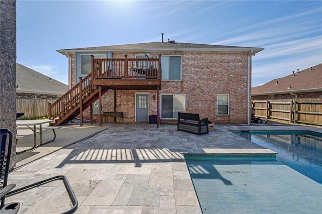 back of house with a swimming pool side deck and a patio area