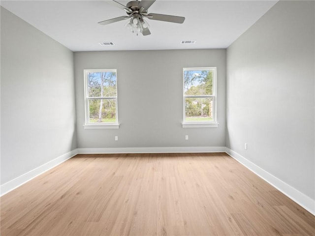 unfurnished room with ceiling fan, light wood-type flooring, and plenty of natural light