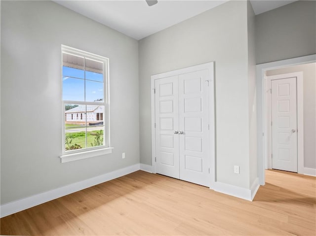 unfurnished bedroom with ceiling fan, a closet, and light hardwood / wood-style flooring