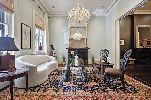 sitting room with ornamental molding, a chandelier, and hardwood / wood-style flooring