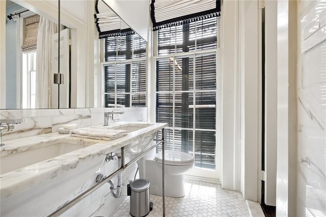 bathroom featuring dual sinks, tasteful backsplash, toilet, large vanity, and tile floors