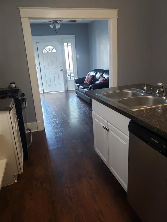 kitchen with dark hardwood / wood-style flooring, sink, white cabinetry, and stainless steel dishwasher