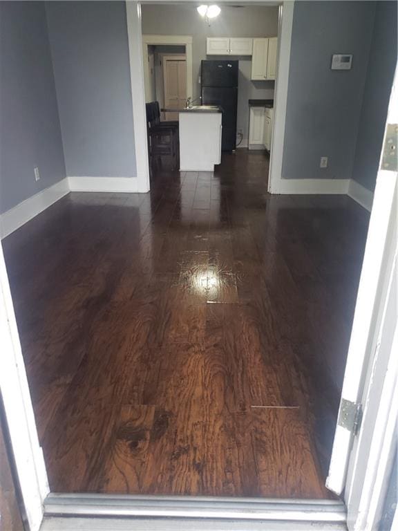 kitchen featuring white cabinets, fridge, a center island, and dark hardwood / wood-style flooring