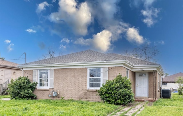 view of front of home with central AC and a front lawn