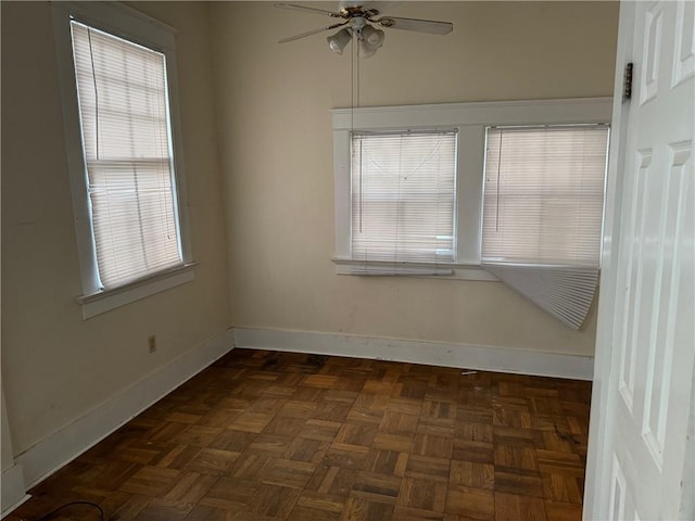 empty room with ceiling fan and dark parquet flooring