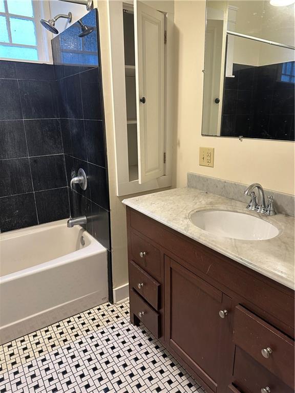 bathroom with vanity, tiled shower / bath, and tile patterned flooring