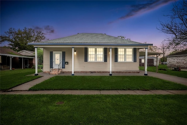 view of front of property featuring a yard and a carport