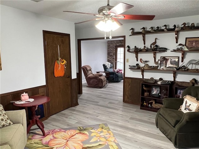 interior space featuring a textured ceiling, ceiling fan, and light wood-type flooring