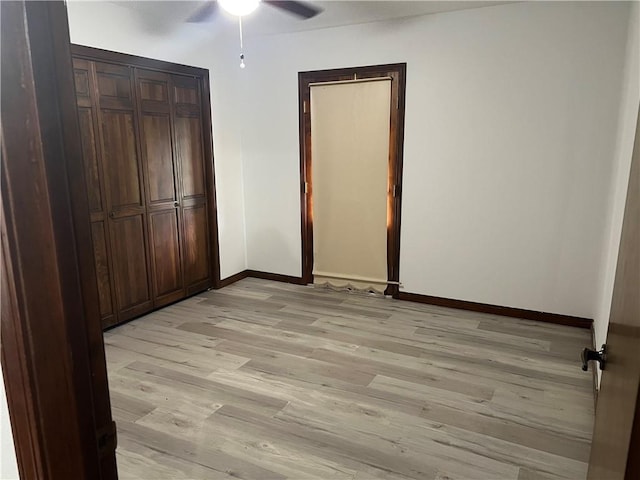 unfurnished bedroom featuring ceiling fan, light wood-type flooring, and a closet