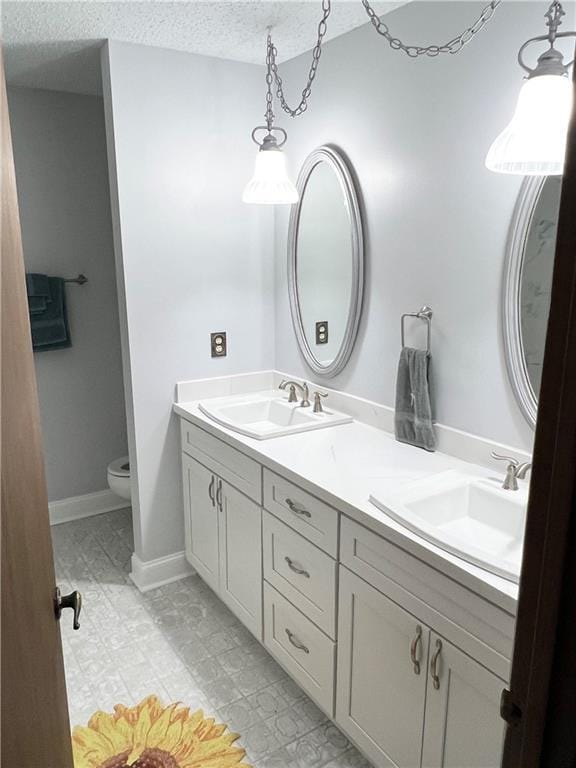 bathroom featuring vanity, a textured ceiling, and toilet