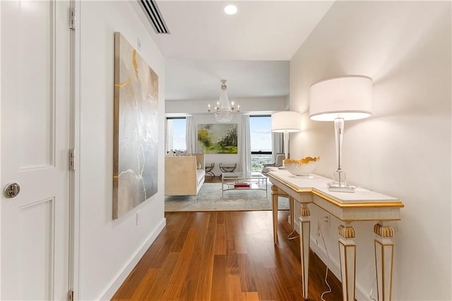 hall featuring an inviting chandelier and dark hardwood / wood-style floors