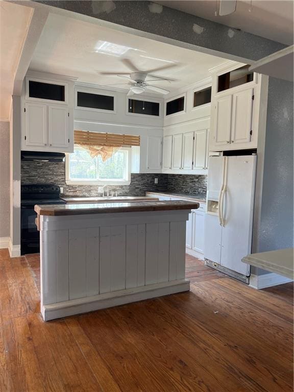 kitchen with electric range oven, dark hardwood / wood-style floors, white refrigerator with ice dispenser, and white cabinetry