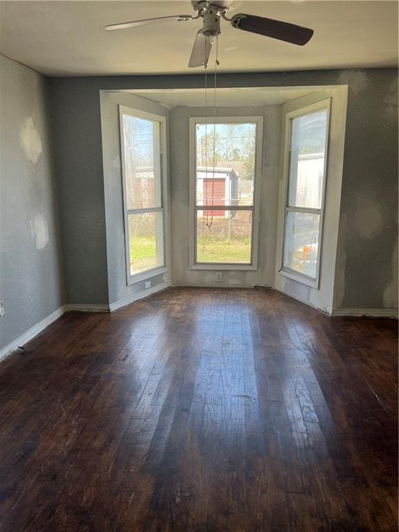 unfurnished room featuring dark hardwood / wood-style floors and ceiling fan