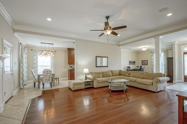 living room with ceiling fan, ornamental molding, light tile floors, and ornate columns