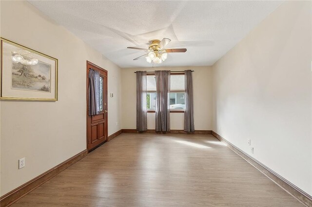 spare room featuring ceiling fan, dark wood-type flooring, and a textured ceiling