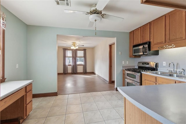 kitchen with light tile floors, ceiling fan, appliances with stainless steel finishes, and sink