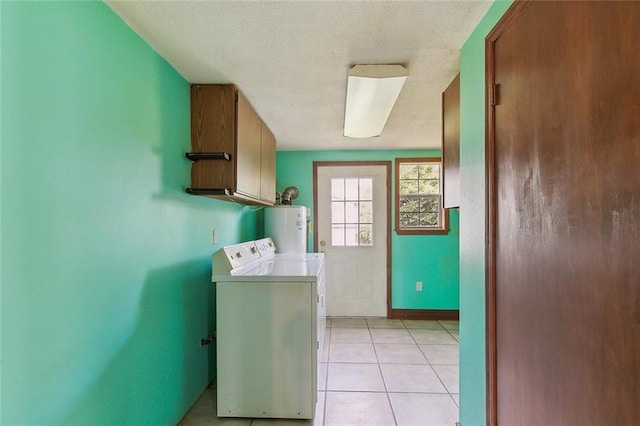 laundry area with cabinets, washer and clothes dryer, light tile flooring, water heater, and a textured ceiling