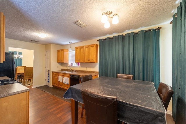 kitchen featuring decorative light fixtures, a textured ceiling, black appliances, dark hardwood / wood-style floors, and sink