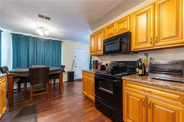 kitchen featuring dark hardwood / wood-style flooring, a textured ceiling, and black appliances