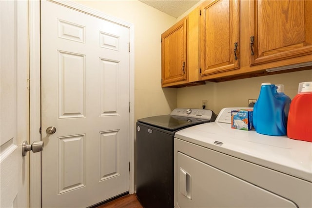 laundry area featuring cabinets, separate washer and dryer, and dark hardwood / wood-style floors