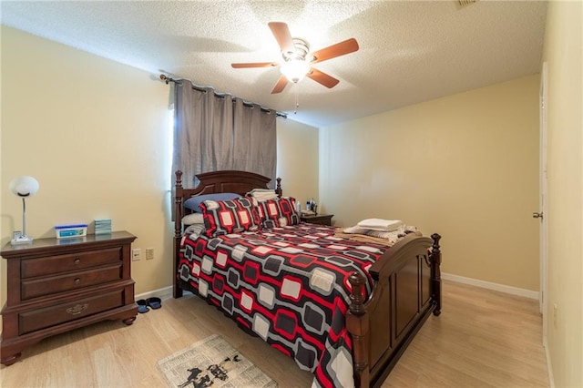 bedroom featuring ceiling fan, light wood-type flooring, and a textured ceiling