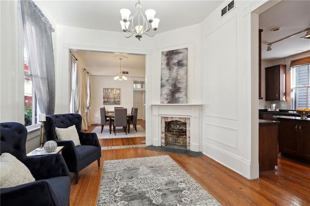 living room with a notable chandelier, a wealth of natural light, and wood-type flooring