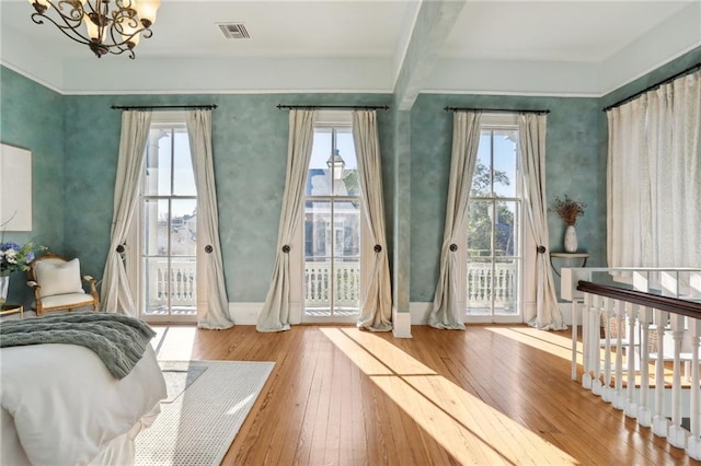 bedroom with a chandelier, access to exterior, and light wood-type flooring