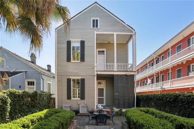 back of property with a balcony and central air condition unit