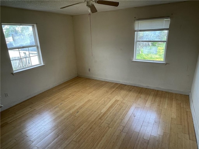 spare room with a textured ceiling, light hardwood / wood-style floors, and ceiling fan