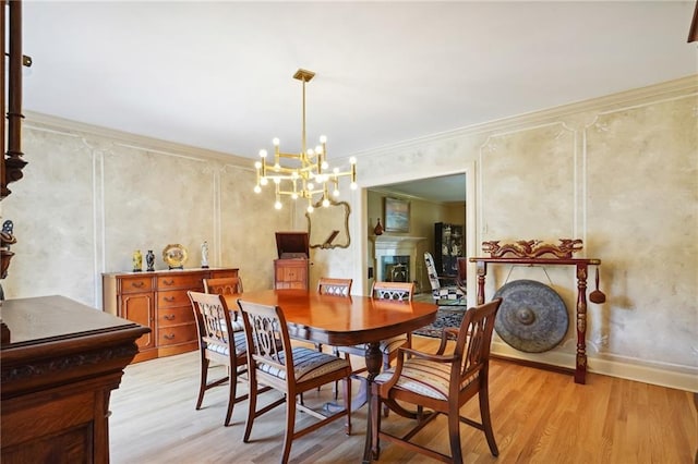 dining room featuring light hardwood / wood-style flooring, ornamental molding, and an inviting chandelier