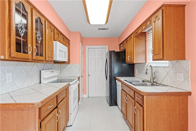 kitchen with light tile flooring, sink, white appliances, and backsplash