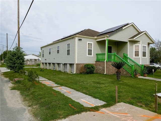 view of property exterior with covered porch, solar panels, and a yard