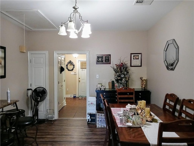 dining area with dark wood-type flooring and a chandelier