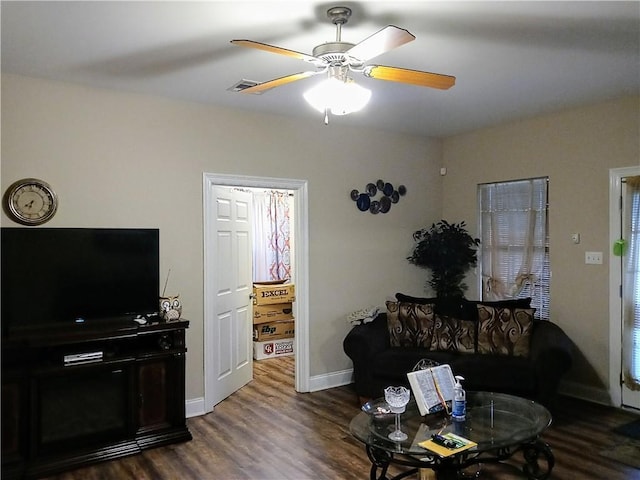 living room featuring ceiling fan and dark wood-type flooring