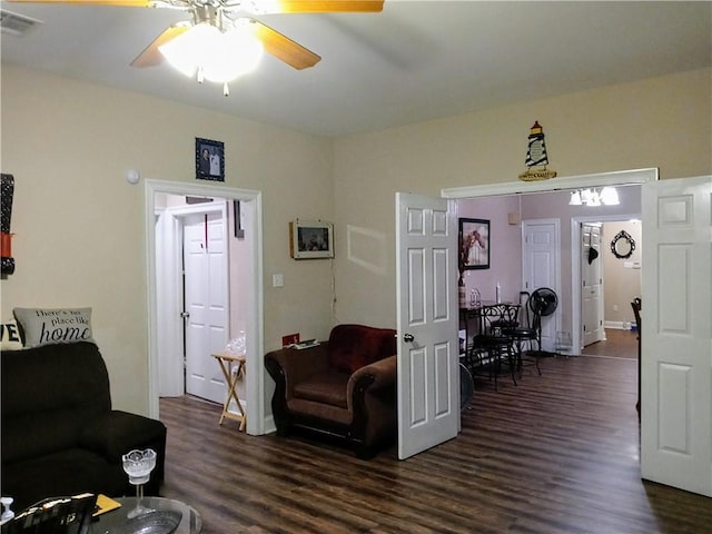 living room featuring ceiling fan and dark wood-type flooring